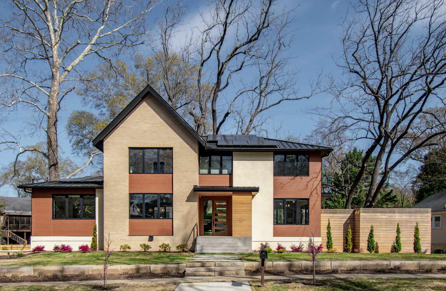 Modern house exterior with brick stucco wood accents black windows