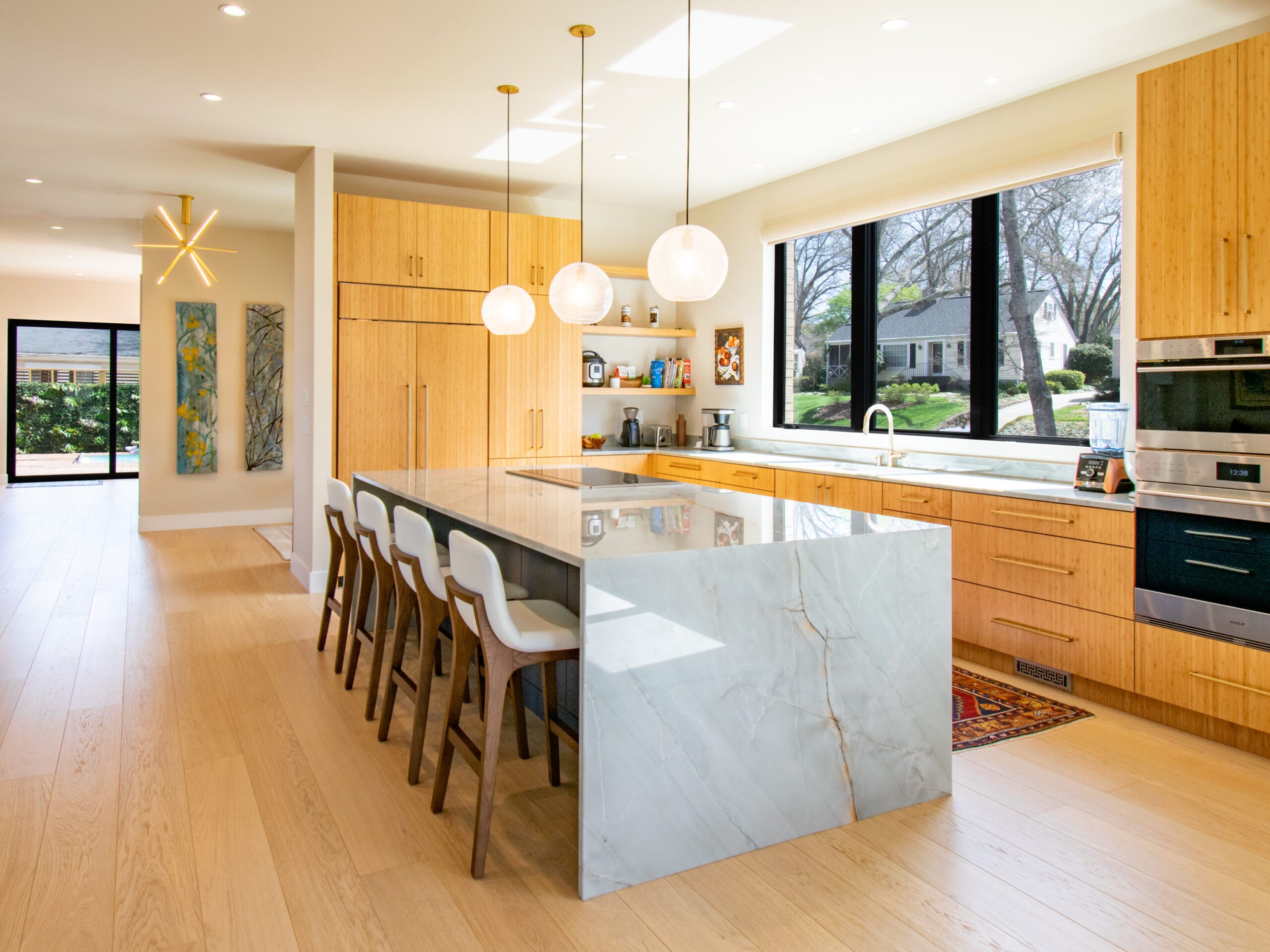 Modern kitchen with wood cabinets and quartz island with waterfall edge