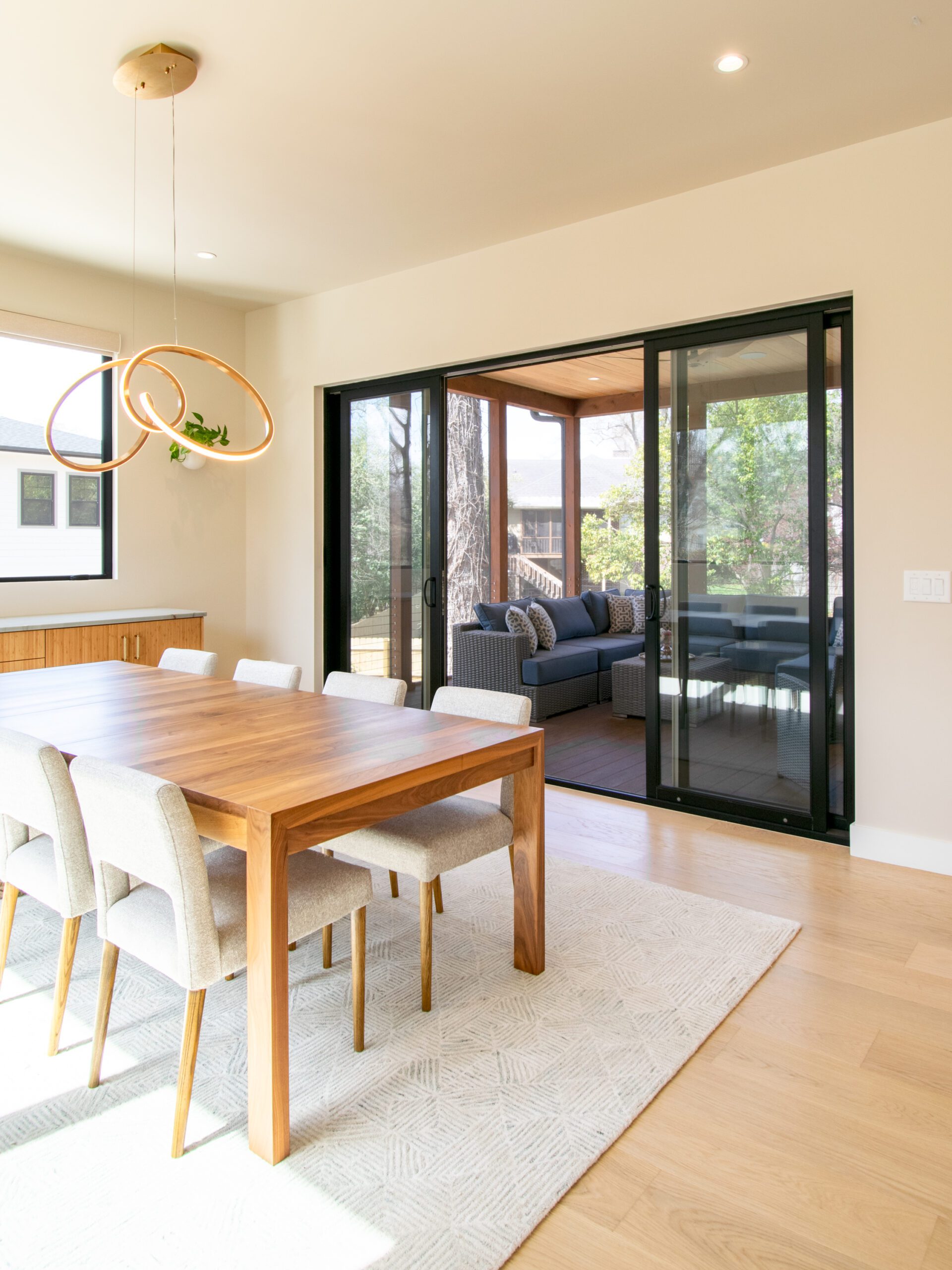 Bifold black aluminum clad wood door open to screen porch