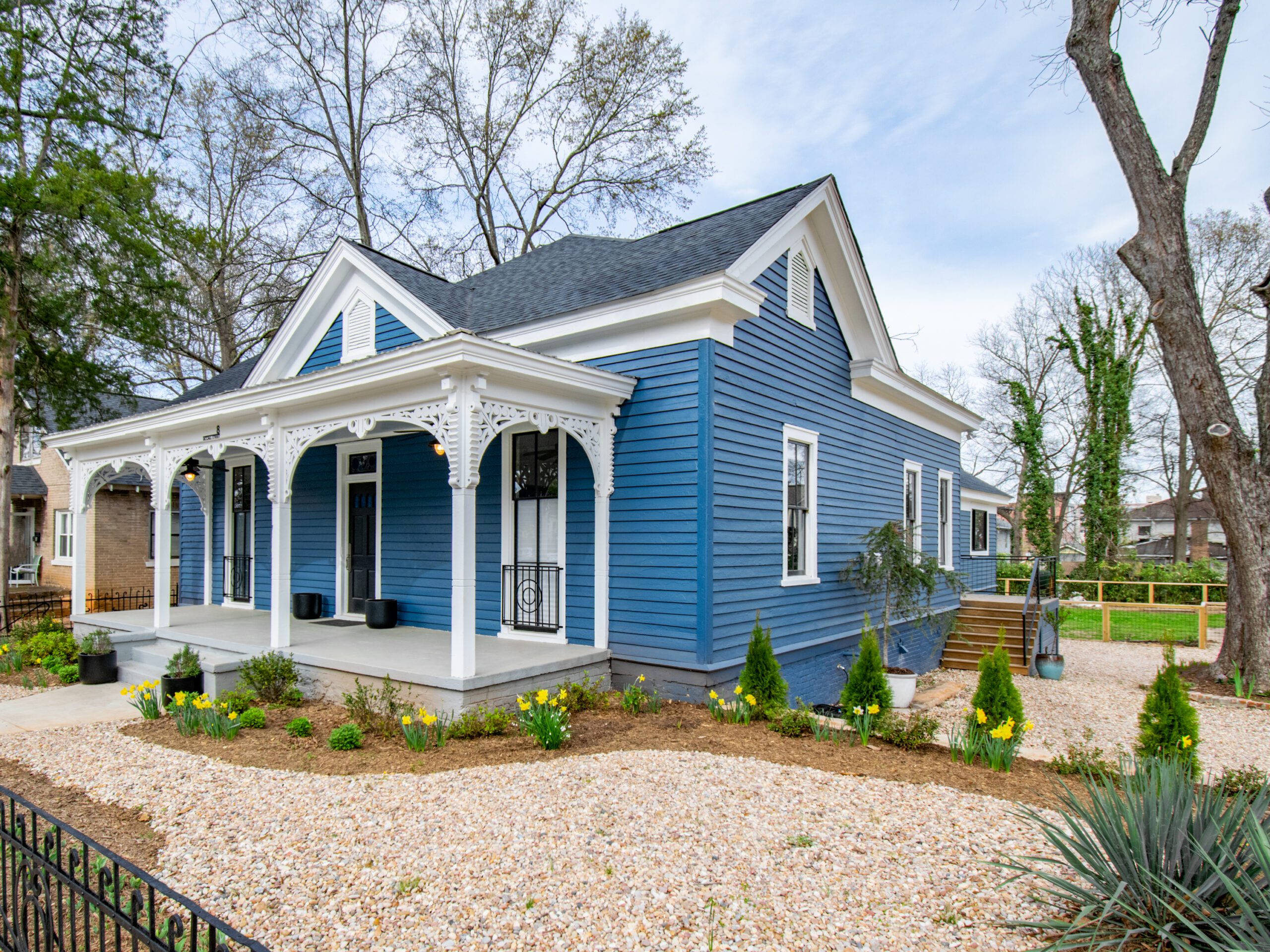 Blue Victorian home with front porch and gingerbread detail