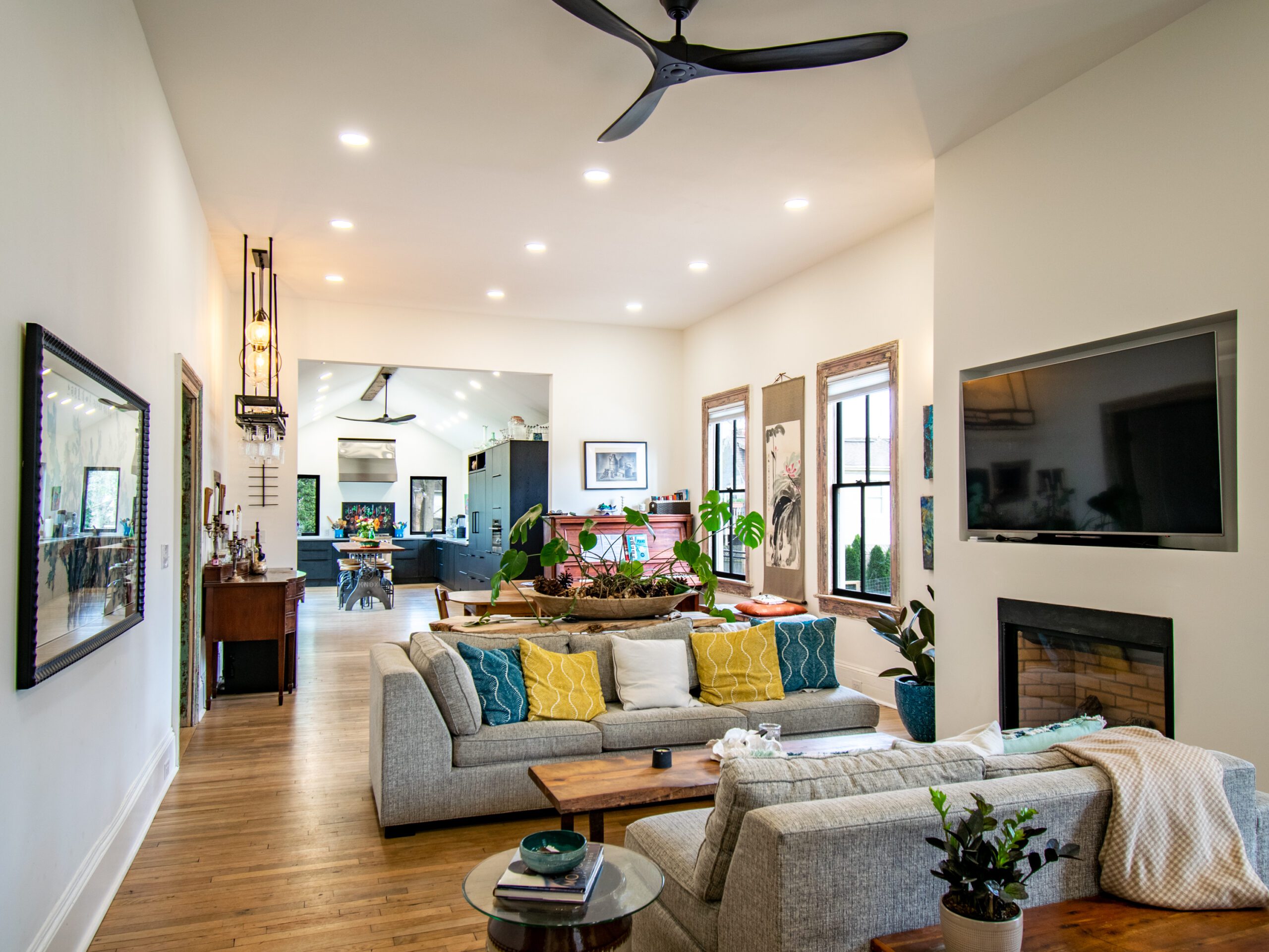 View of open living and dining room leading to kitchen in renovated Victorian house