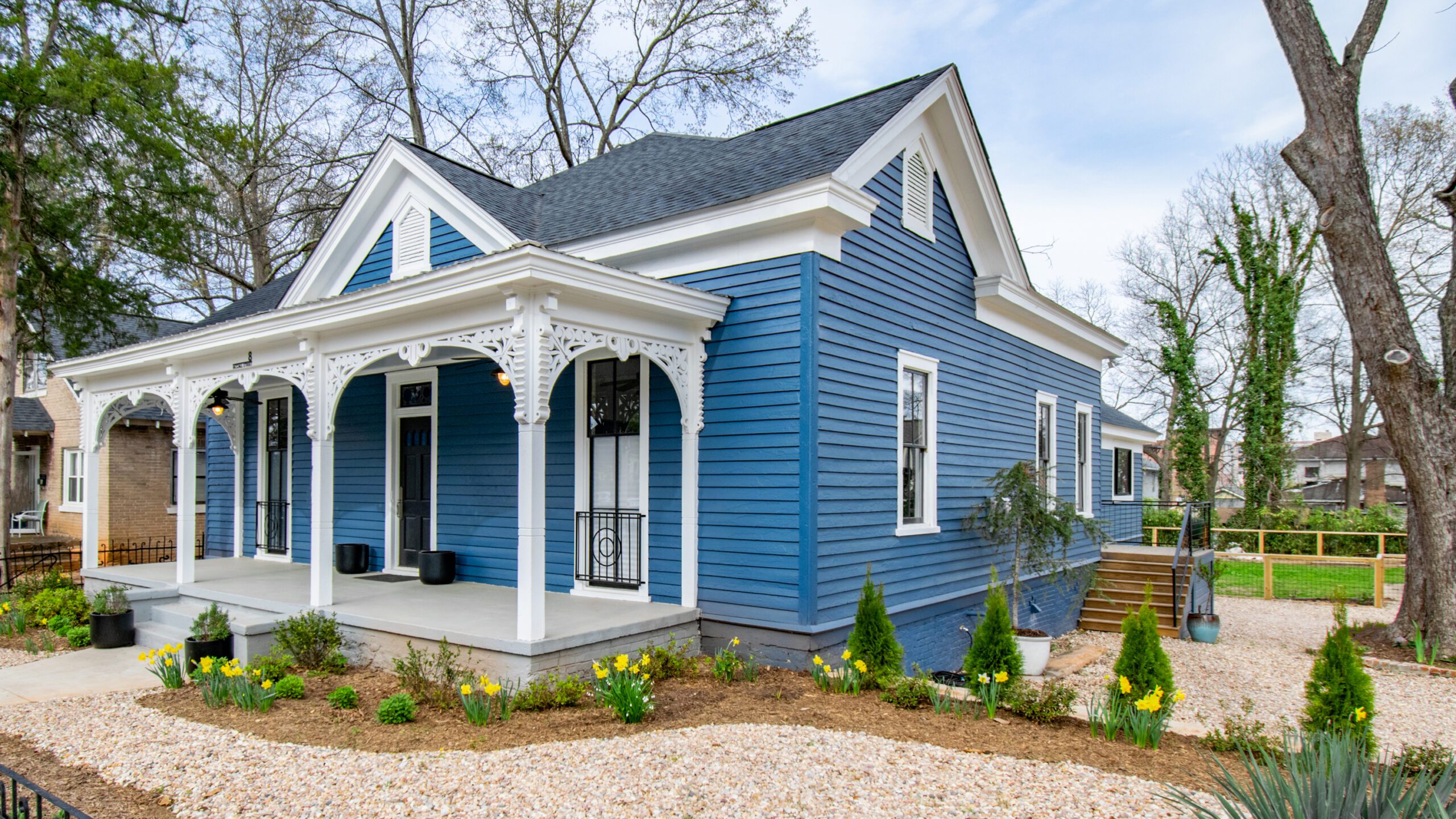 Blue Victorian home with front porch and gingerbread detail